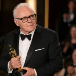 Anthony Hopkins holding an Oscar at an awards ceremony for an article about his net worth