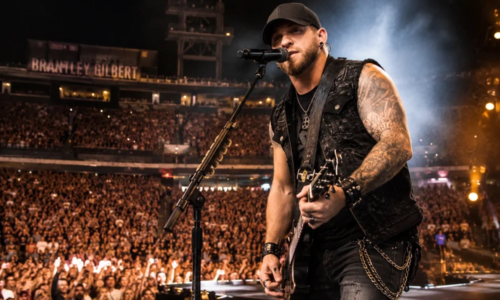 Brantley Gilbert’s live concert coverage featuring a country rock singer playing guitar on stage before a packed crowd.