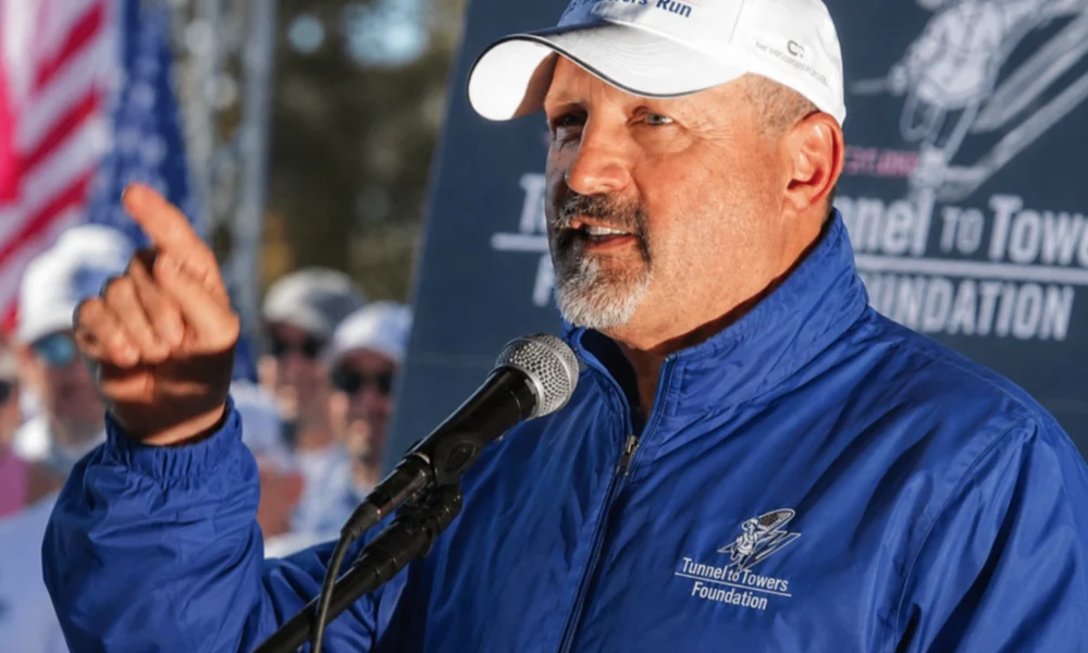 Frank Siller speaking at a Tunnel to Towers Foundation event with microphone and raised hand