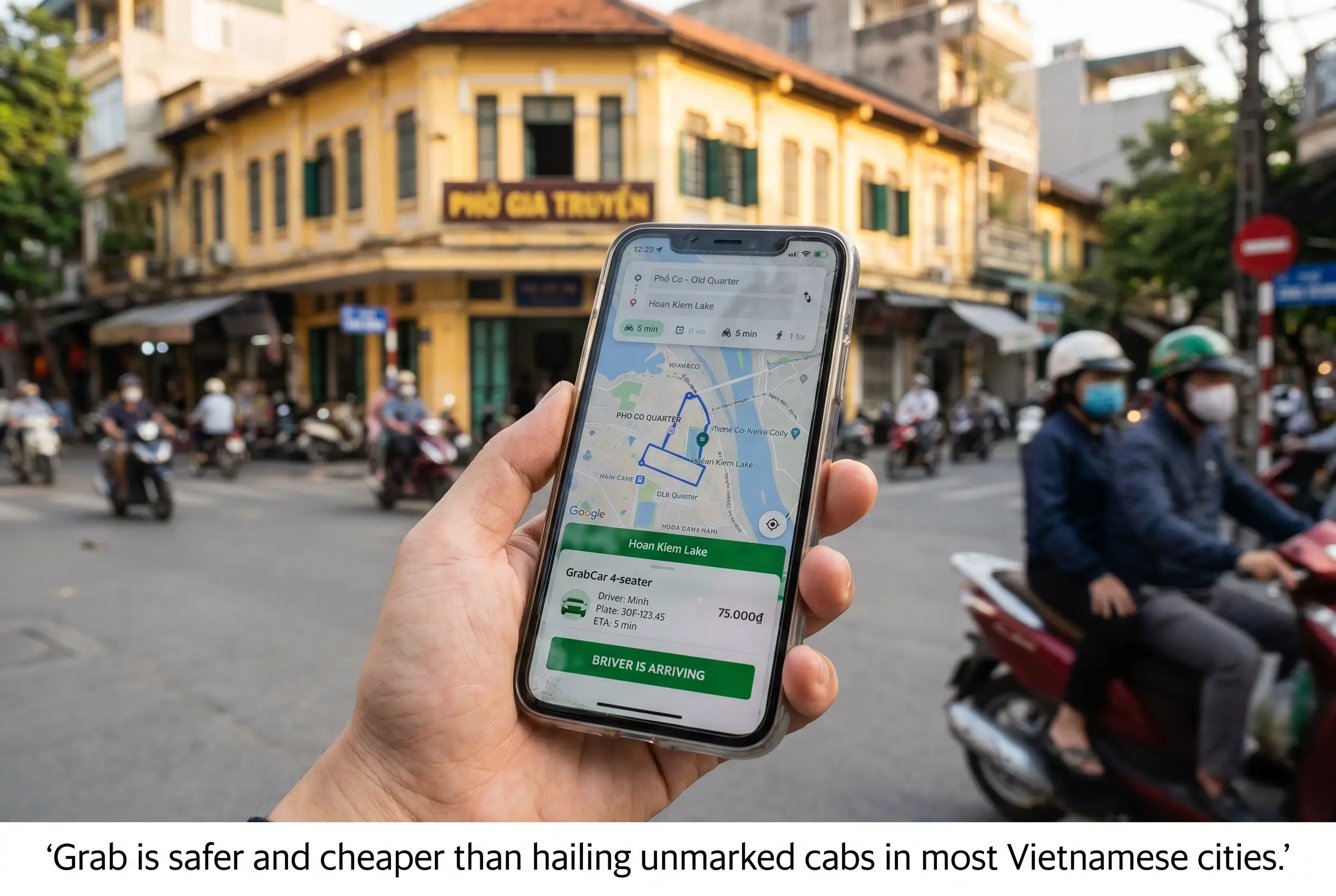 Hand holding a phone showing a Grab ride booking in Hanoi’s Old Quarter with scooter traffic in the background.