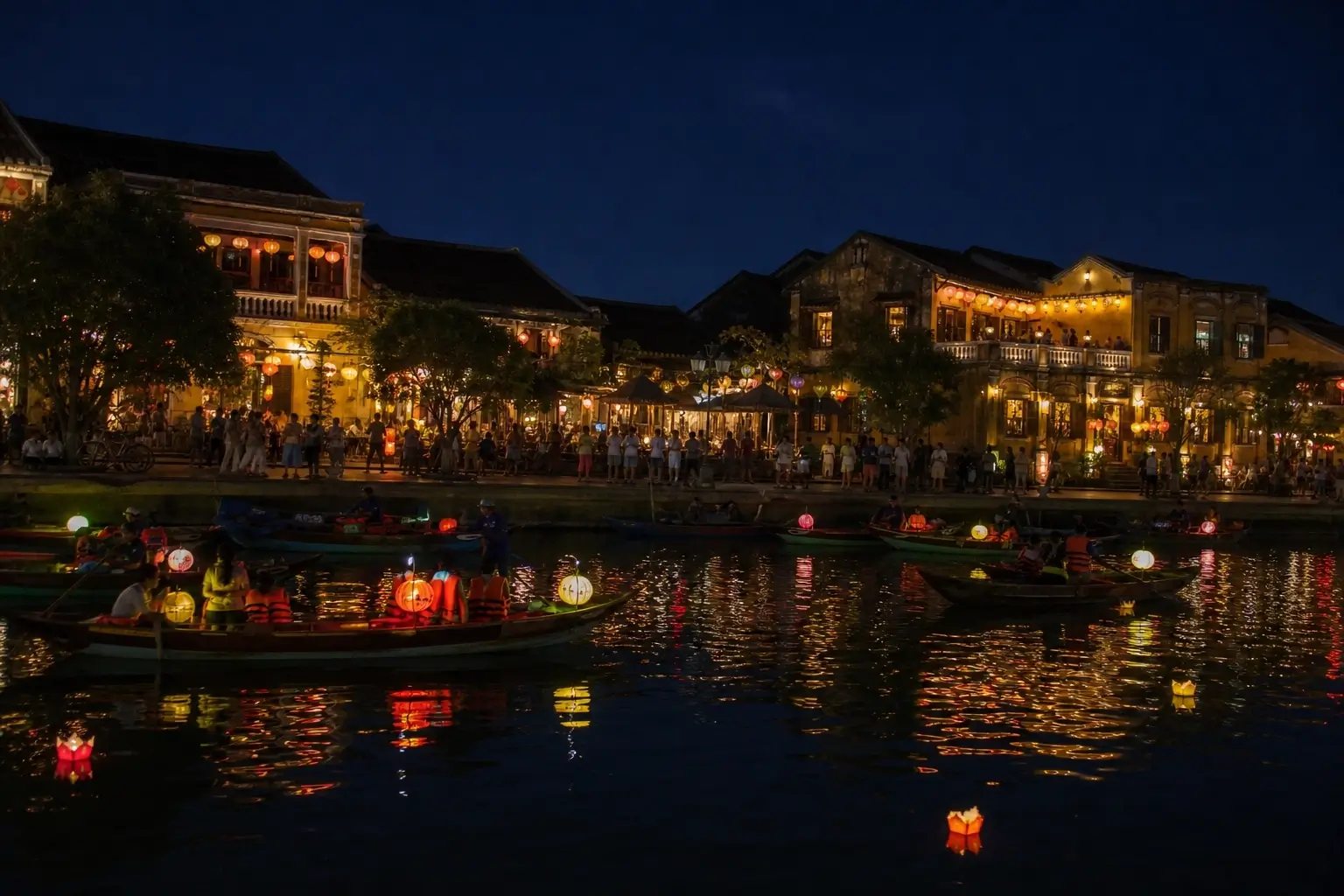Hoi An Ancient Town at night with lantern boats and glowing reflections on the Thu Bon River