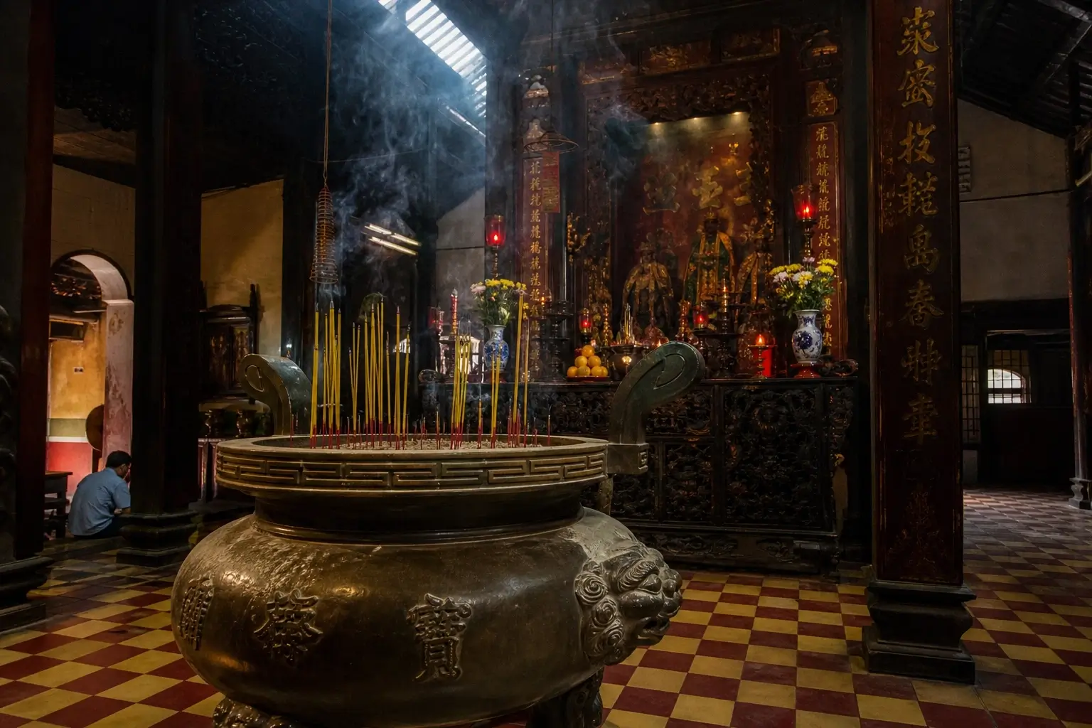 Interior of Jade Emperor Pagoda in Saigon with incense smoke, carved altar, and temple statues.