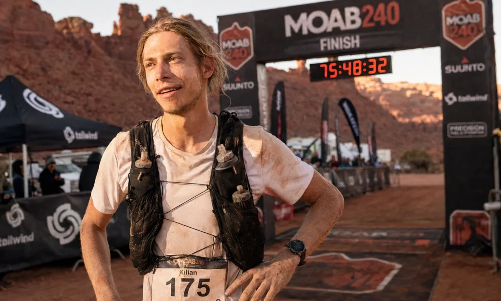Kilian Korth at the Moab 240 finish line with Utah desert canyon backdrop