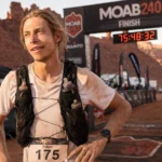 Kilian Korth at the Moab 240 finish line with Utah desert canyon backdrop