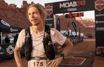 Kilian Korth at the Moab 240 finish line with Utah desert canyon backdrop
