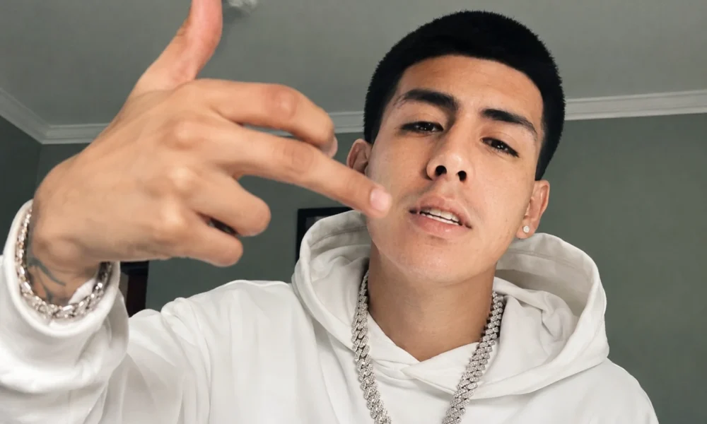 Lalo Gone Brazy wearing a white hoodie and diamond chain in a portrait photo