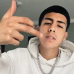 Lalo Gone Brazy wearing a white hoodie and diamond chain in a portrait photo