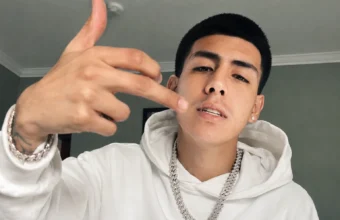 Lalo Gone Brazy wearing a white hoodie and diamond chain in a portrait photo