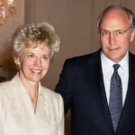 Lynne Cheney wearing a cream jacket at a formal indoor event with a suited man beside her.