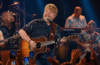 Mac McAnally performs live with acoustic guitar during a tropical concert stage performance