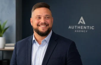 Mike Nellis professional headshot in navy blazer with Authentic Agency background