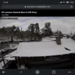 Mt Lemmon webcam live view showing snow on the General Store rooftop and surrounding mountain road conditions.