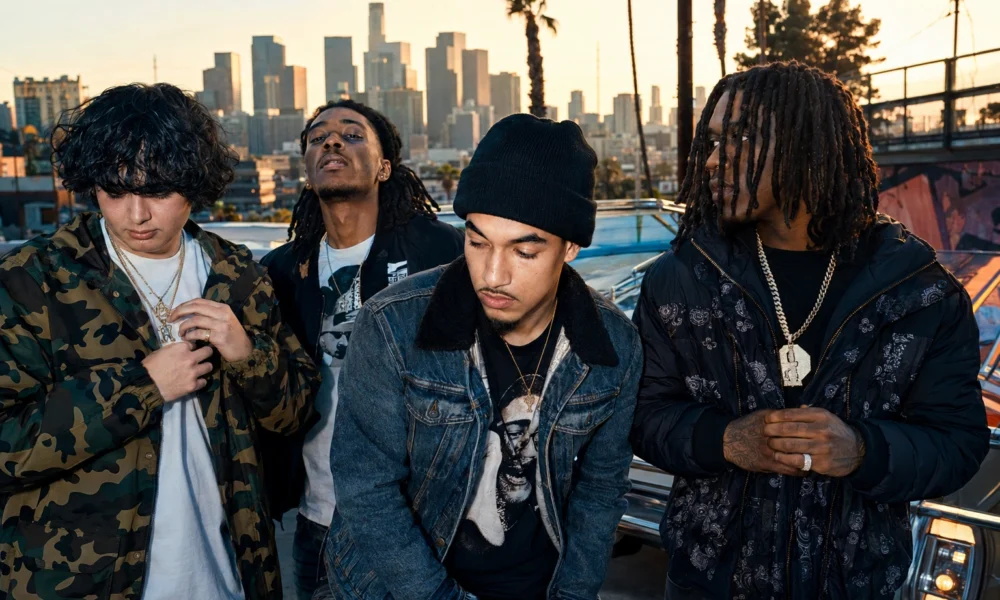 Shoreline Mafia-style hip-hop group promo photo with four artists in front of a Los Angeles skyline.