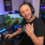 SSundee's gaming setup with headset, microphone, RGB keyboard, and Minecraft gameplay on monitors
