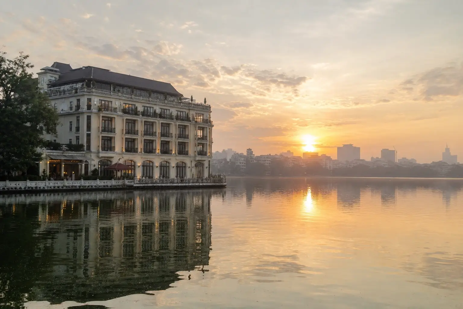 Boutique hotel beside West Lake in Hanoi at sunrise with golden reflections on the water