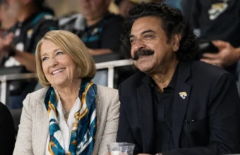 Ann Carlson Khan and Shahid Khan smiling together at a Jacksonville Jaguars game.