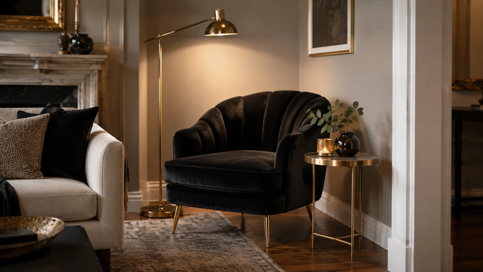 Black velvet accent chair with a gold side table in a cozy living room corner.