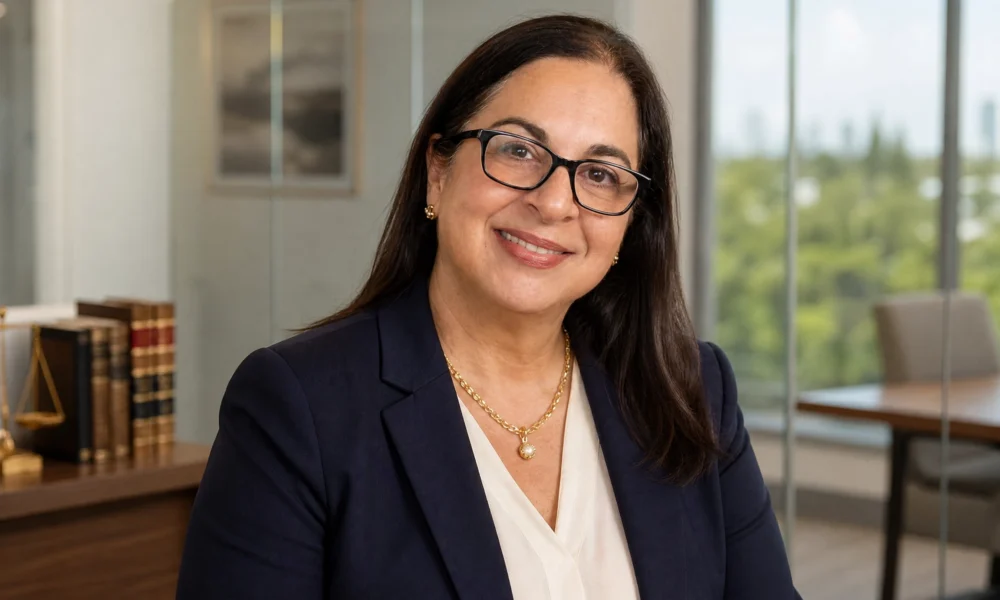 Cristy Garcia professional portrait in navy blazer and glasses