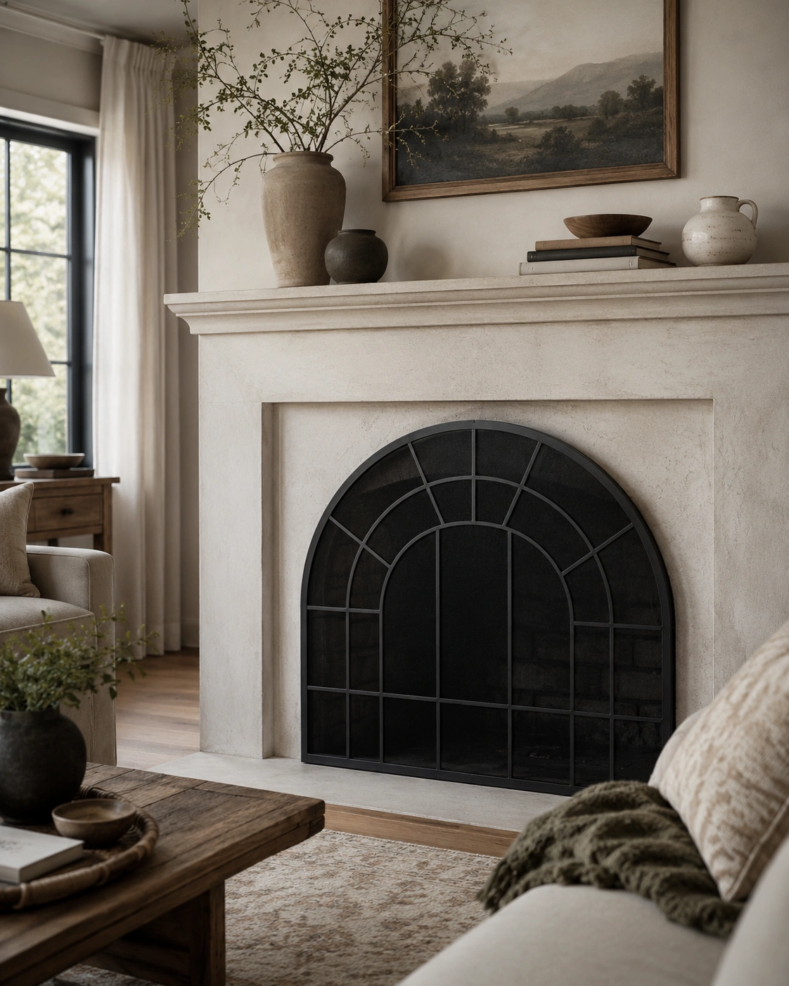 Neutral living room fireplace with black arched decorative screen and styled mantel decor