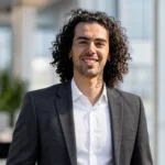 Edoardo Cristoni portrait-style image showing a smiling man in a dark suit