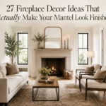 Elegant neutral living room with styled fireplace mantel, gold mirror, candles, sofa, and balanced seating.