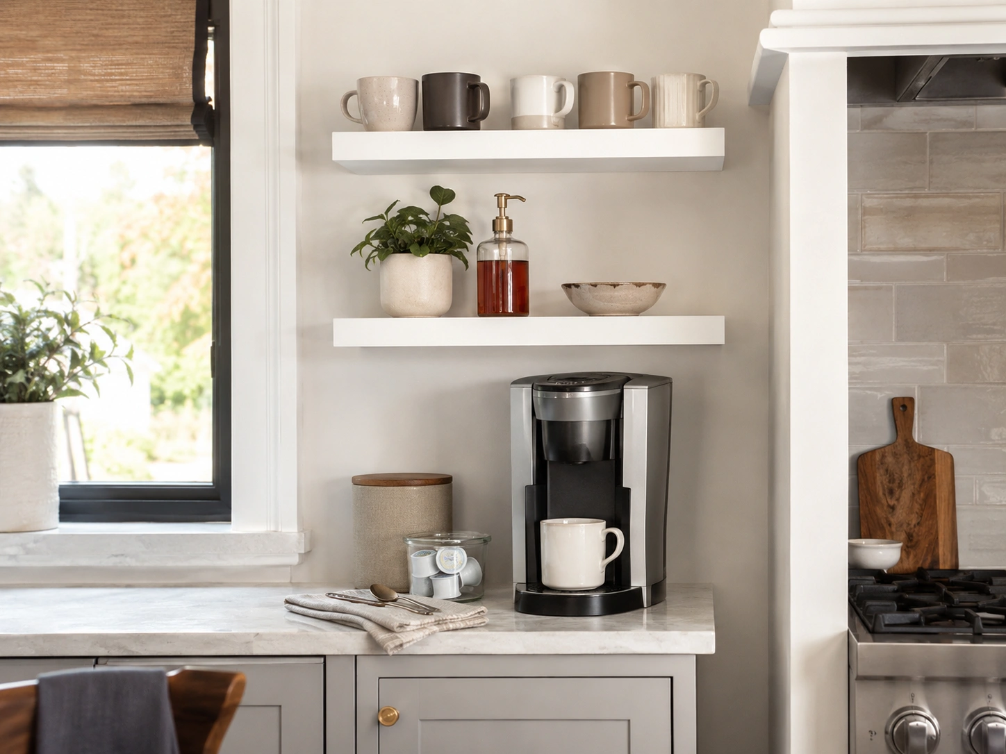 Corner Counter Coffee Nook With Wraparound Shelf Dead counter corners are an underused asset in almost every kitchen layout. A single L-shaped or wraparound shelf at 18 to 24 inches above the corner turns dead space into a natural coffee station backdrop — machine in the corner, mugs on the diagonal shelf, pods and supplies on the return. This layout also hides cords better because the corner provides a natural anchor point. It's particularly effective in galley kitchens where straight counter runs don't have natural stopping points. [IMAGE: Corner counter coffee nook with an L-shaped shelf above, espresso machine tucked into the corner, mugs arranged on both sides] 