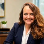 Kara Amstutz, DVM, smiling in a navy blazer during a professional office portrait.