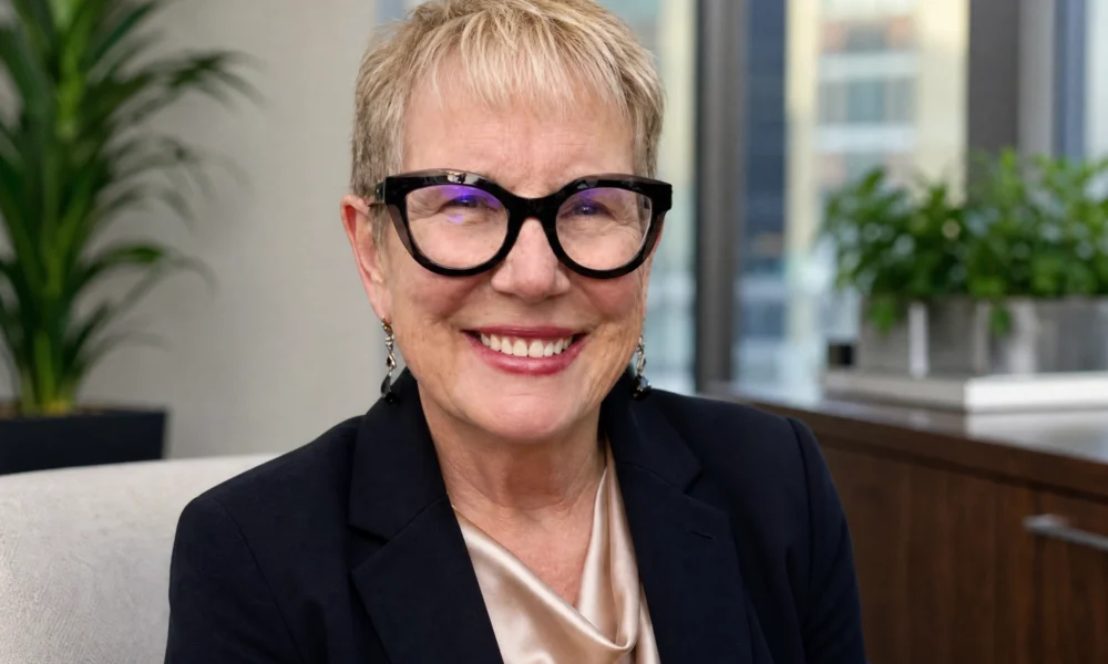 Lorraine Carlson Garavalia smiling in glasses in a professional office setting