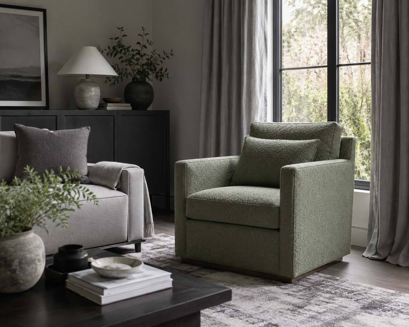 Muted sage green armchair as a focal accent in a grey living room with soft curtains and dark wood decor.