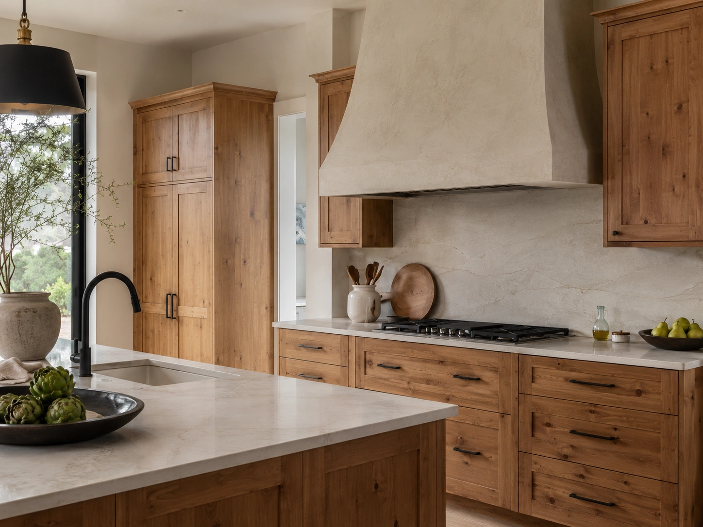 Textured plaster range hood above knotty alder cabinets with white counters and matte black pulls