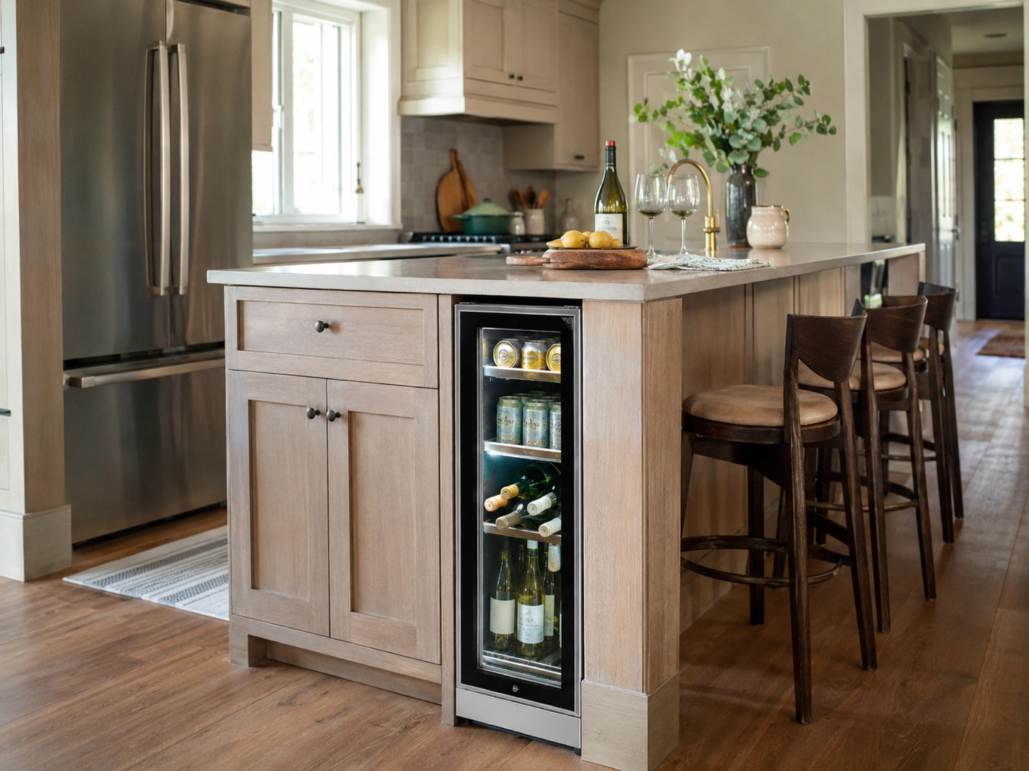Kitchen island with built-in under-counter beverage fridge, wood cabinetry, and bar stools