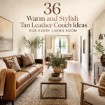 Narrow living room with tan leather couch, neutral pillows, layered rugs, wood table, and warm natural light.