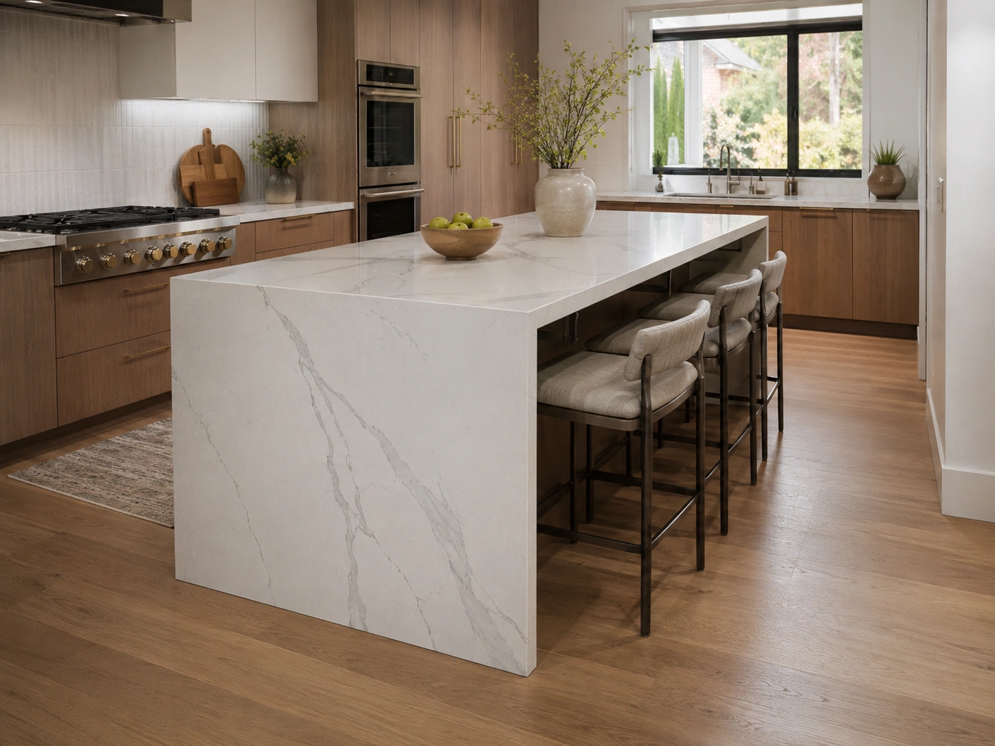 Modern kitchen island with waterfall quartz end, seating overhang, and wood cabinets.