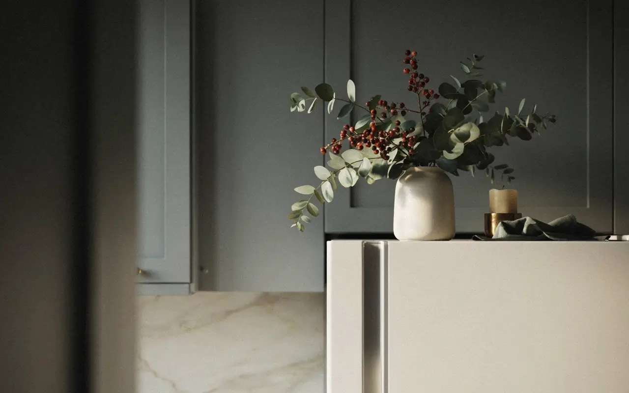 Faux eucalyptus and dried red berry stems arranged in a white ceramic vase for winter decor.