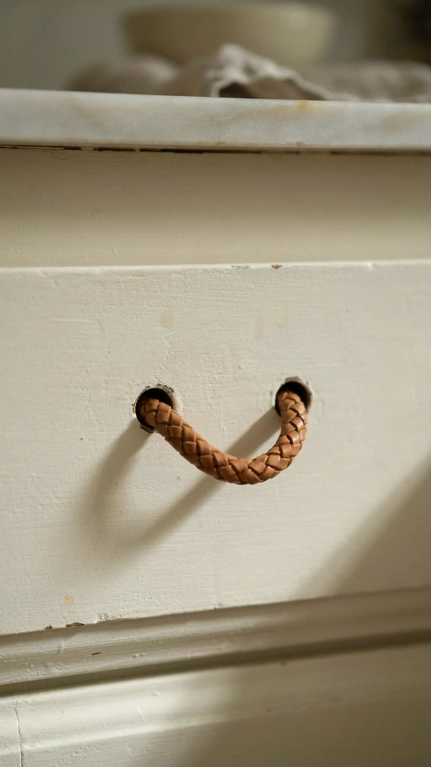 Braided leather drawer strap on a white painted drawer for a rustic furniture update