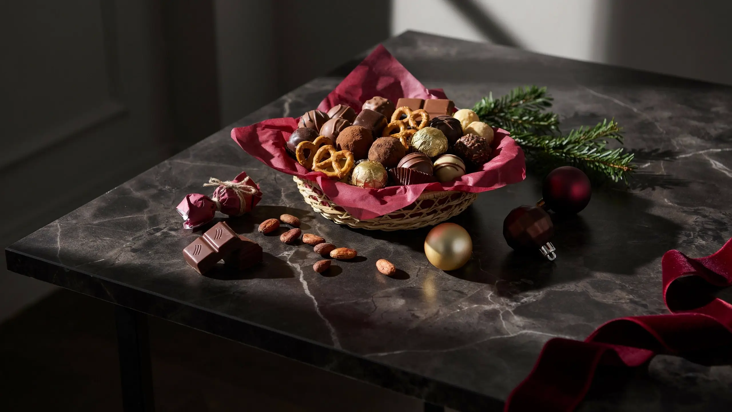 Chocolate lover’s gift basket filled with truffles, chocolate bars, pretzels, nuts, and holiday decorations.