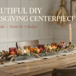 15 Beautiful DIY Thanksgiving Centerpieces Anyone Can Make (Even On a Budget) Rustic DIY Thanksgiving centerpiece with pumpkins, glass candle holders, and dried wheat on a wooden dining table.