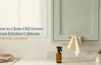 How to clean old grease from kitchen cabinets using a DIY degreasing spray bottle and a soft cleaning cloth, set against a modern subway tile backsplash.