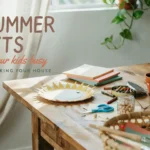 28 Summer Crafts That Keep Your Kids Busy (Without Wrecking Your House) Wooden table with paper plate sun craft, scissors, crayons, and supplies for easy indoor summer kids activities.