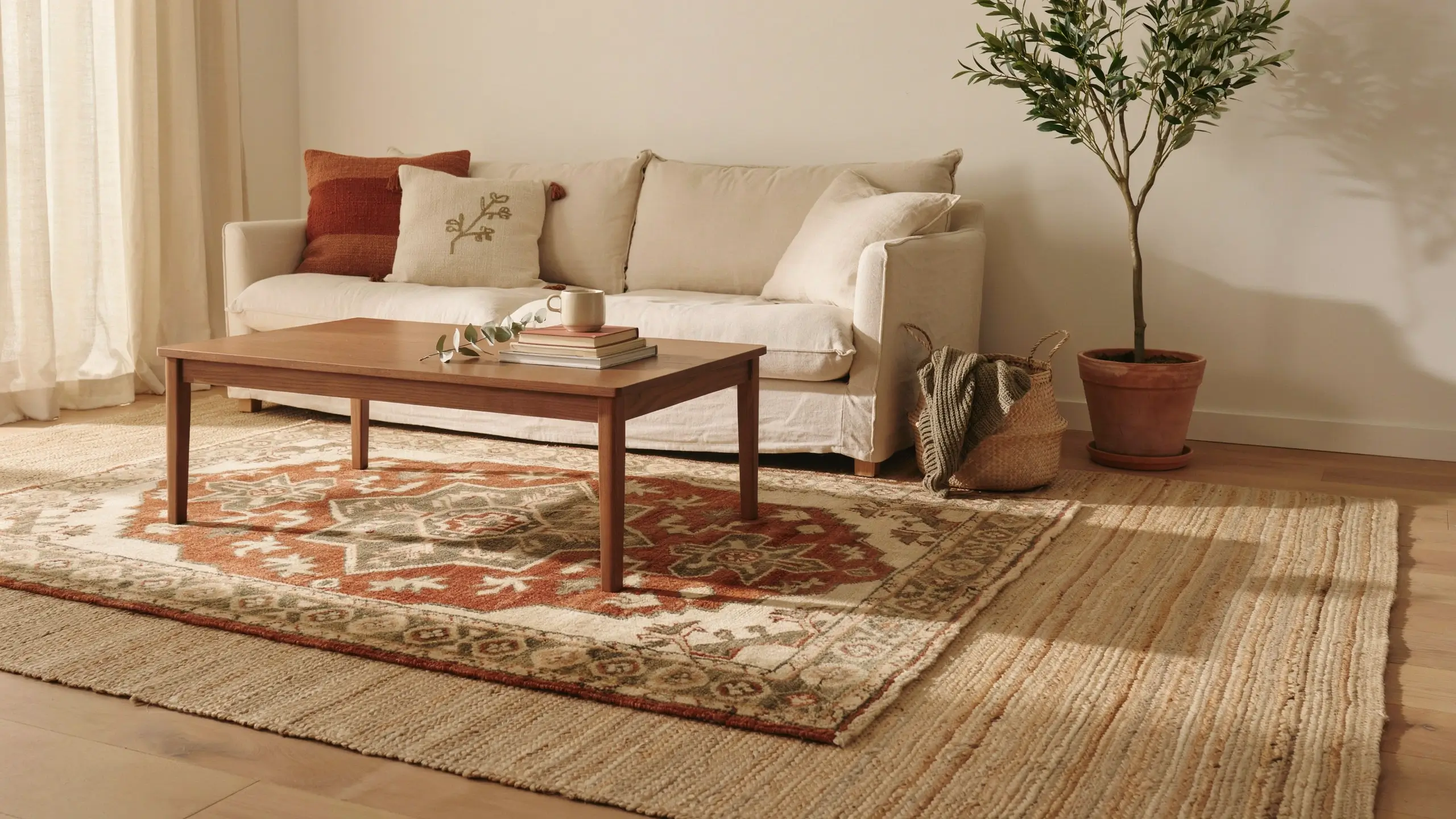 Patterned rug layered over a natural jute rug in a warm boho living room.