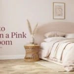 Modern blush pink bedroom design featuring a curved boucle headboard, beige bedding, rattan side table, pampas grass, and an arched floor lamp.