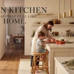 Modern open kitchen with a marble island where a mother and child prepare food together in a warm, bright open-concept home.