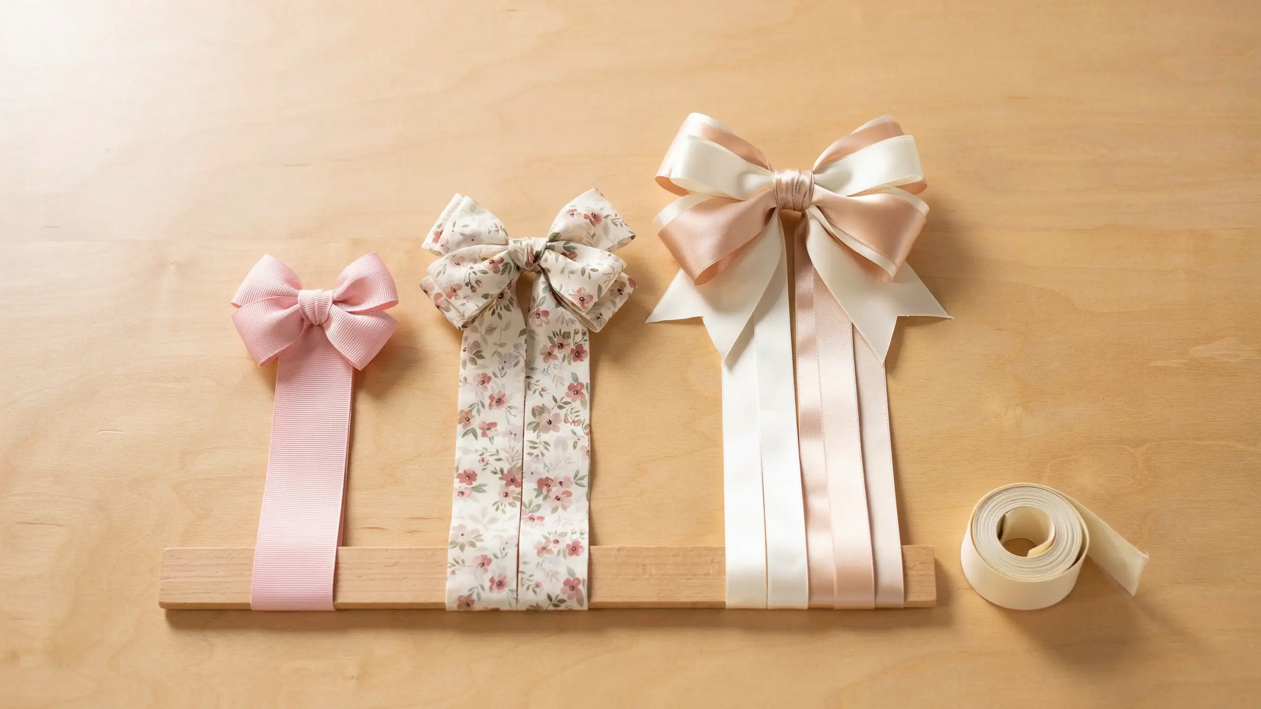 Small, medium, and large ribbon hair bows displayed to compare bow sizing by age.