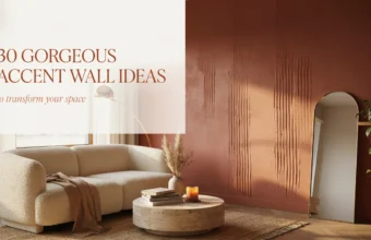 Modern living room featuring a textured terracotta accent wall, white boucle sofa, round travertine coffee table with books and candle, and arched floor mirror reflecting warm sunlight.