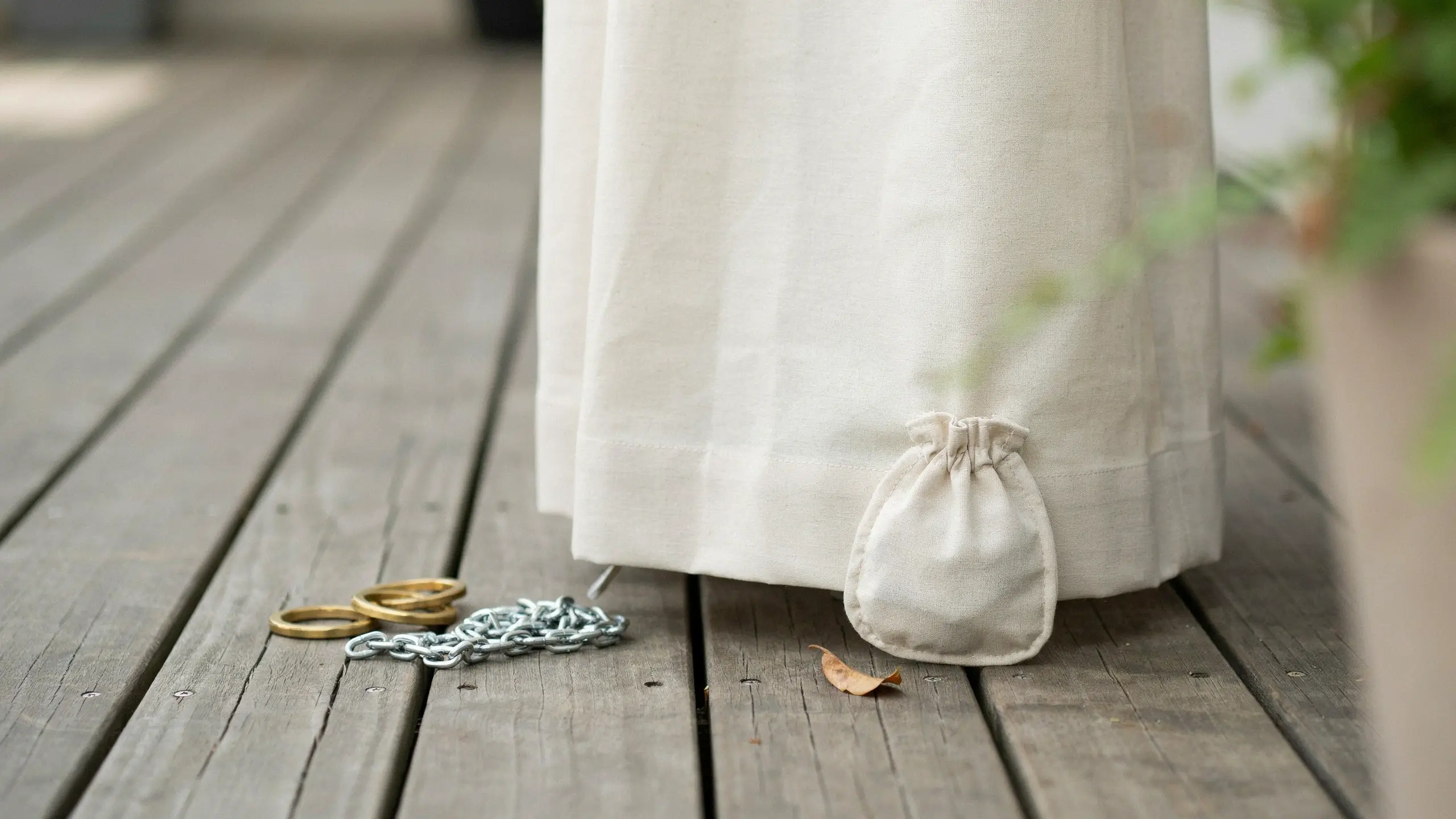 Outdoor beige linen curtain with a weighted drawstring pouch sewn into the bottom hem to prevent wind blow and maintain patio privacy