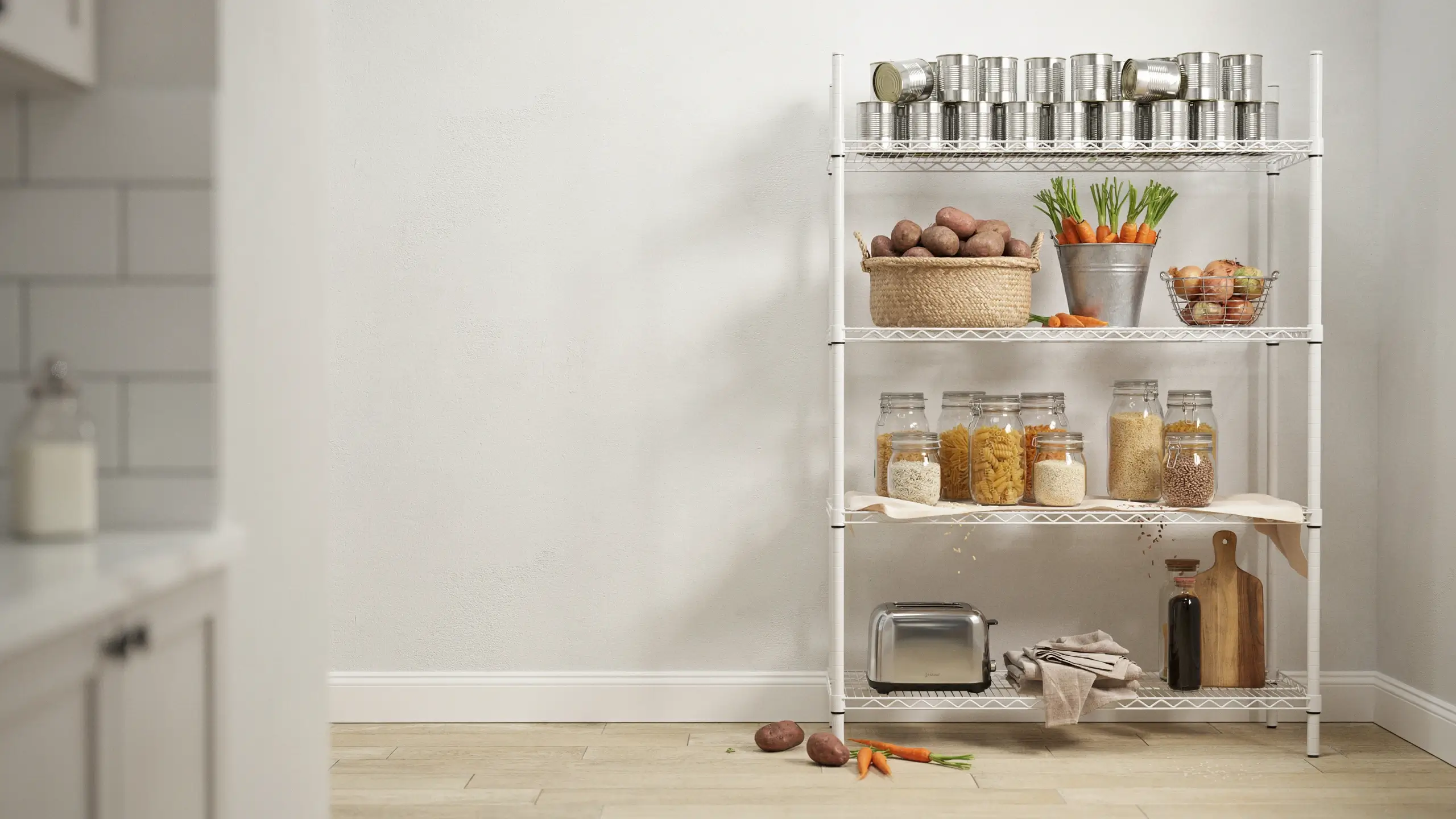 White wire pantry shelving unit holding a woven basket of red potatoes, a silver bucket of fresh carrots, and neatly organized glass storage jars filled with pasta and whole grains on a kitchen counter. 