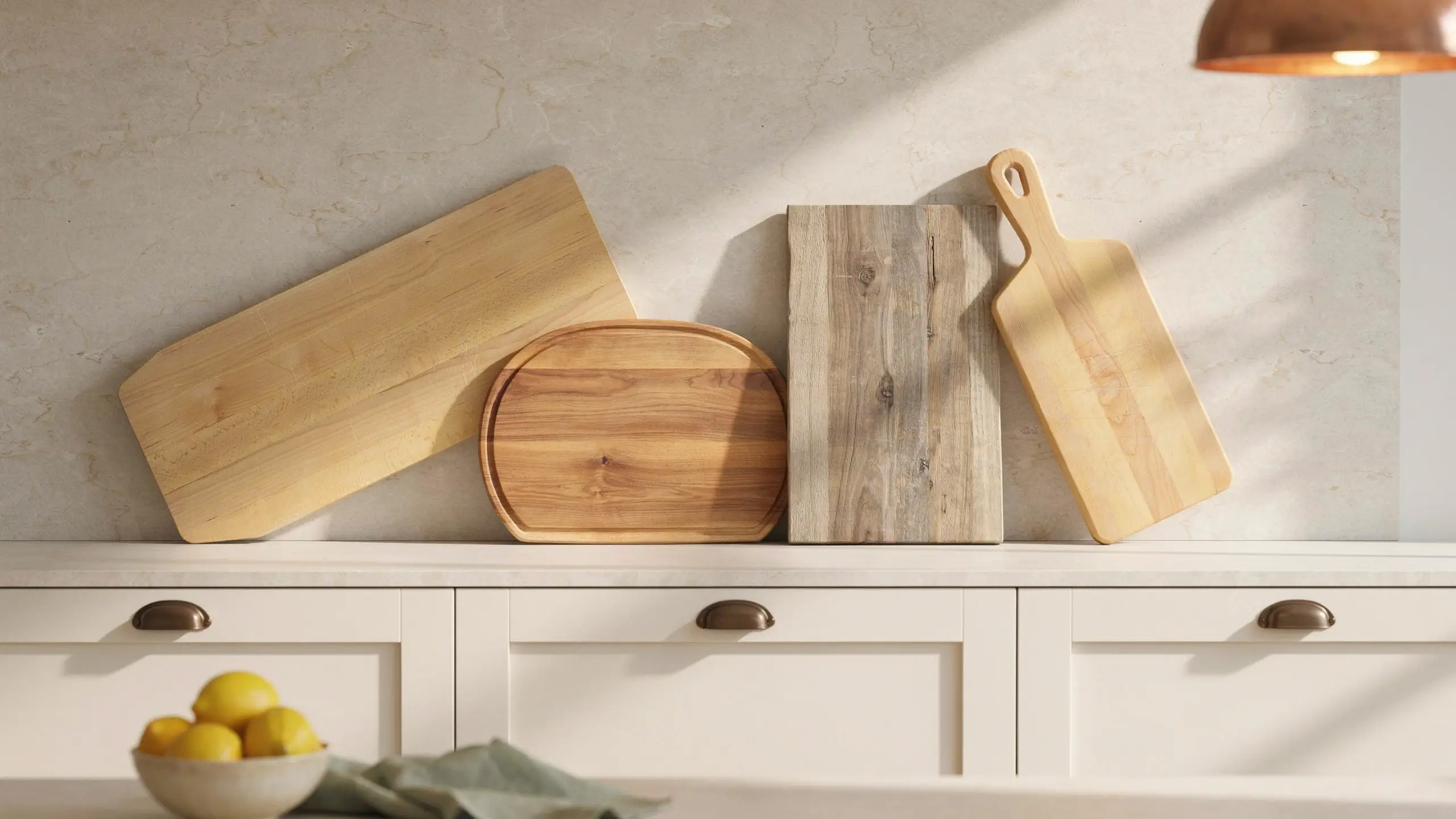 Wooden cutting boards and bread boards leaned in a row against a neutral kitchen backsplash.