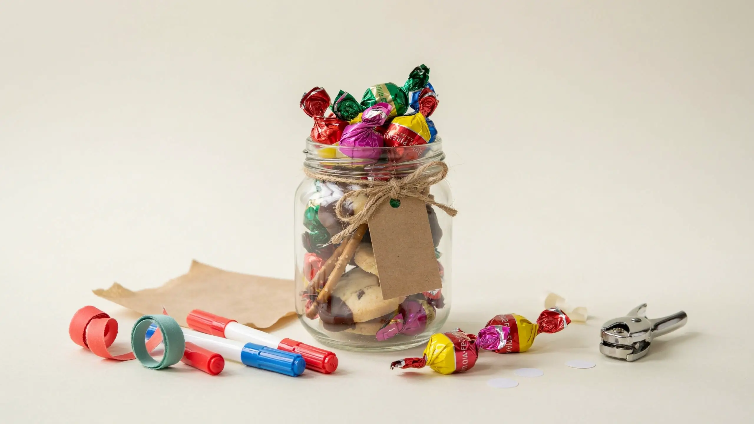 Homemade “You’re Sweet” teacher treat jar filled with colorful candy and cookies, tied with twine and a kraft tag.