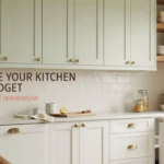 Bright kitchen with sage green upper cabinets and white lower drawers featuring modern gold hardware. A cutting board with lemon and glass pantry jars sit on the counter, demonstrating an affordable kitchen makeover without a full renovation.