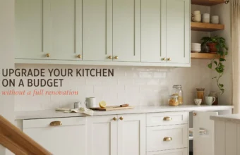 Bright kitchen with sage green upper cabinets and white lower drawers featuring modern gold hardware. A cutting board with lemon and glass pantry jars sit on the counter, demonstrating an affordable kitchen makeover without a full renovation.